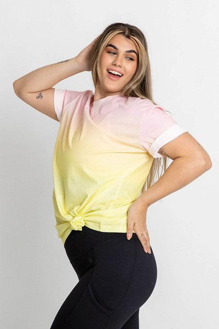 Plus size woman poses in a pink and yellow tshirt