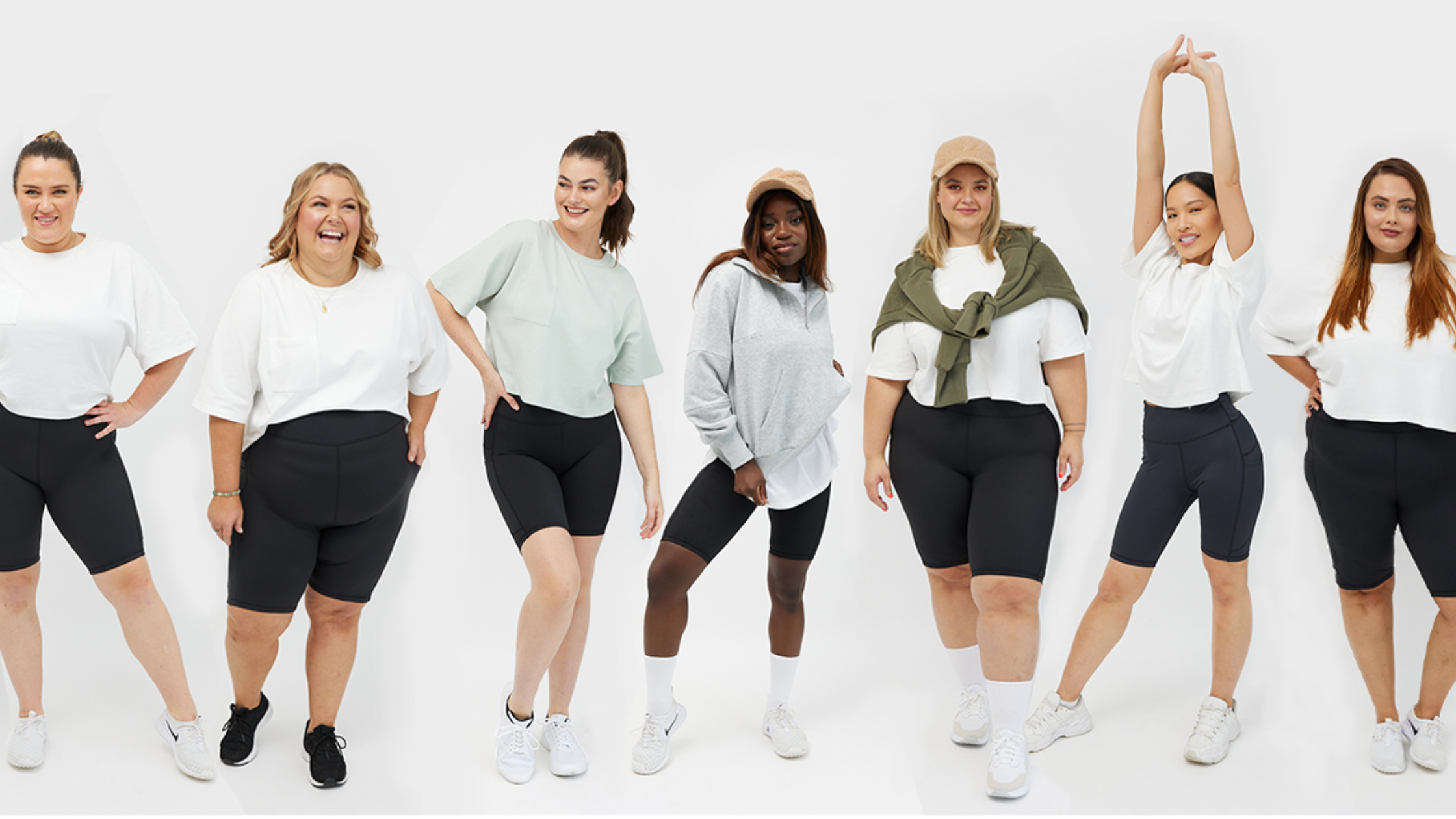 A diverse group of women pose in activewear. They all look happy.