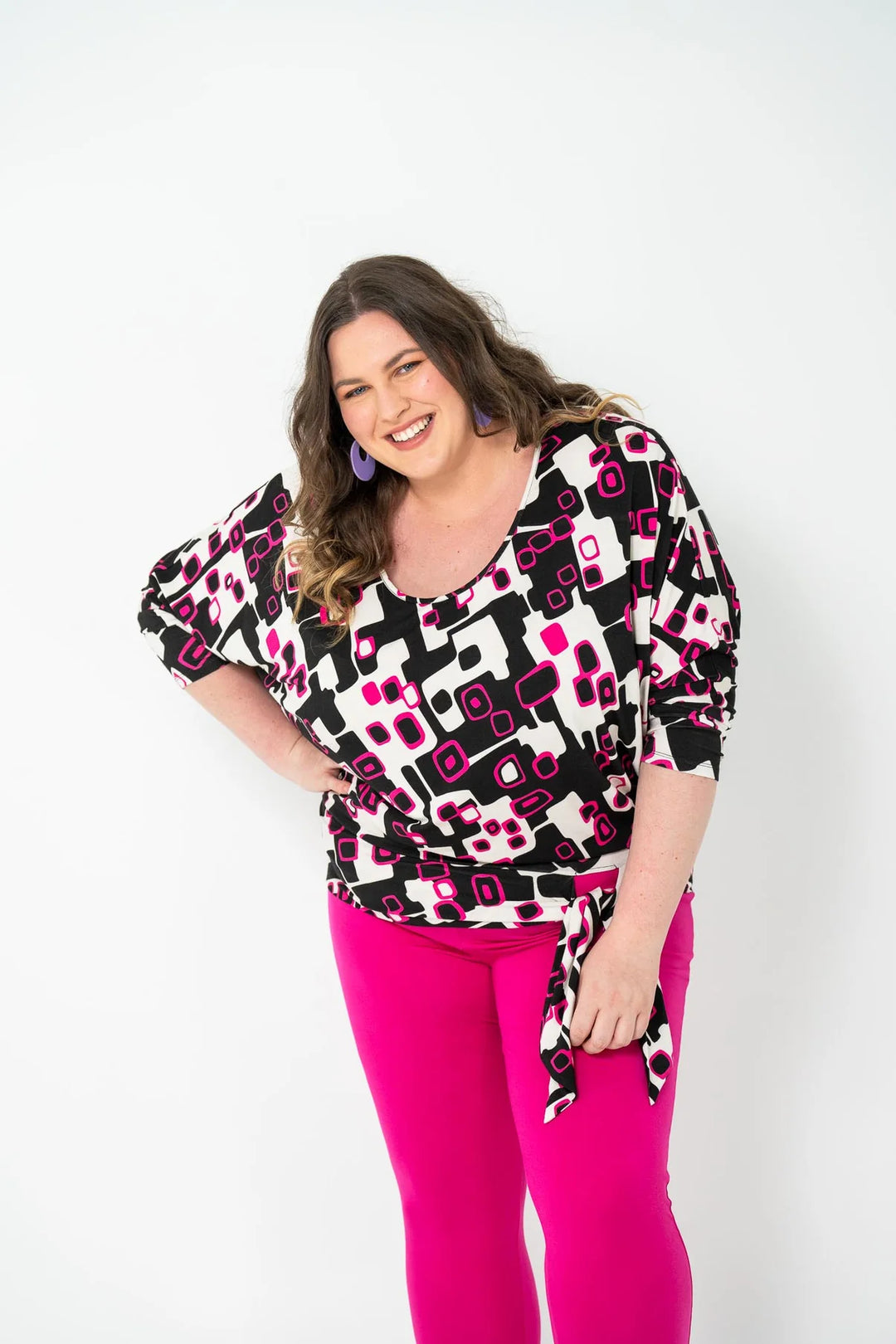 plus size woman wearing bat wing with black and pink prints and pink bottoms