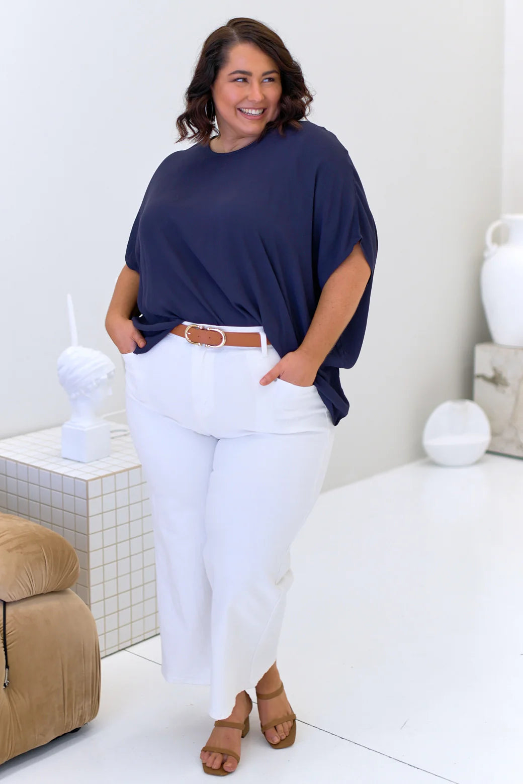 plus size woman wearing navy top and white pants