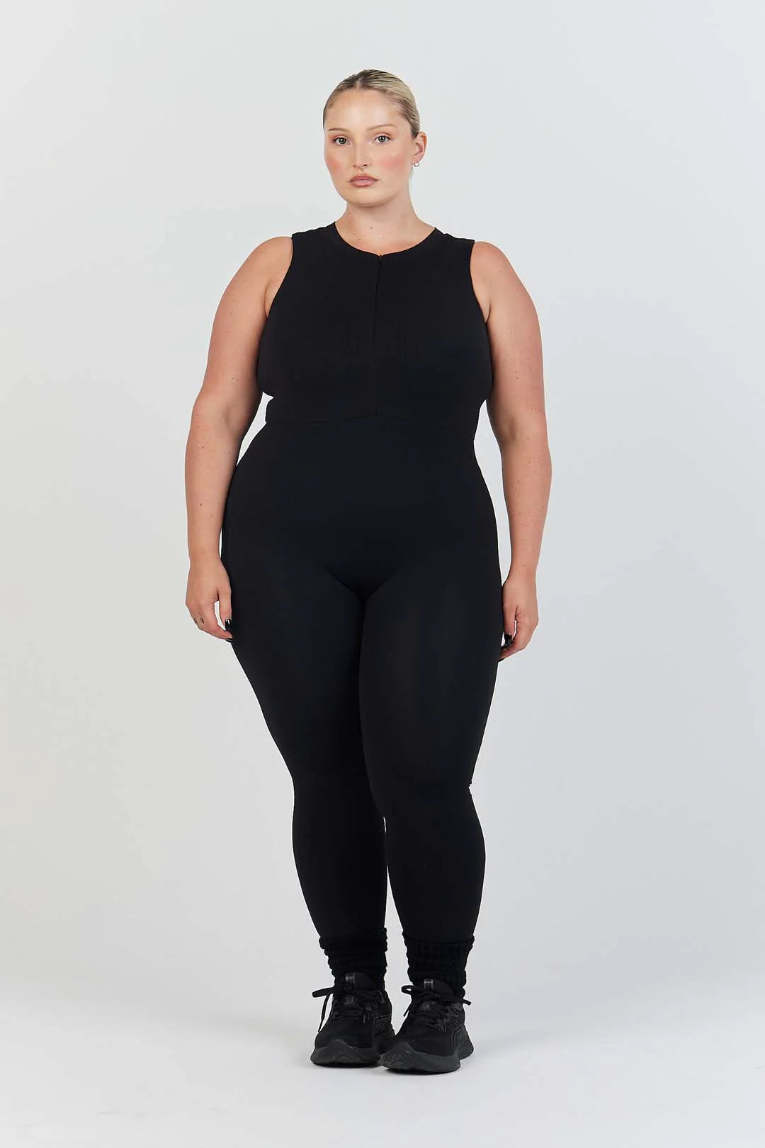 plus size woman wearing black tank top and leggings