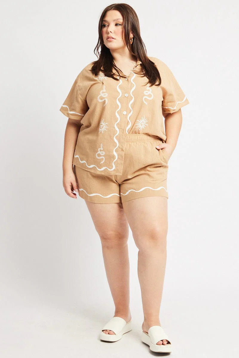 plus size woman wearing brown buttoned top and shorts