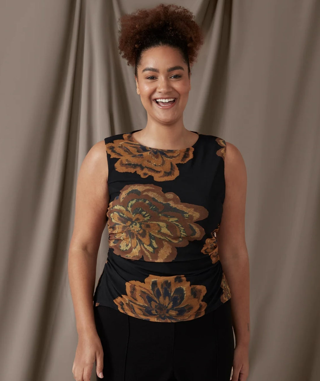 woman wearing sleeveless black top with brown flower design