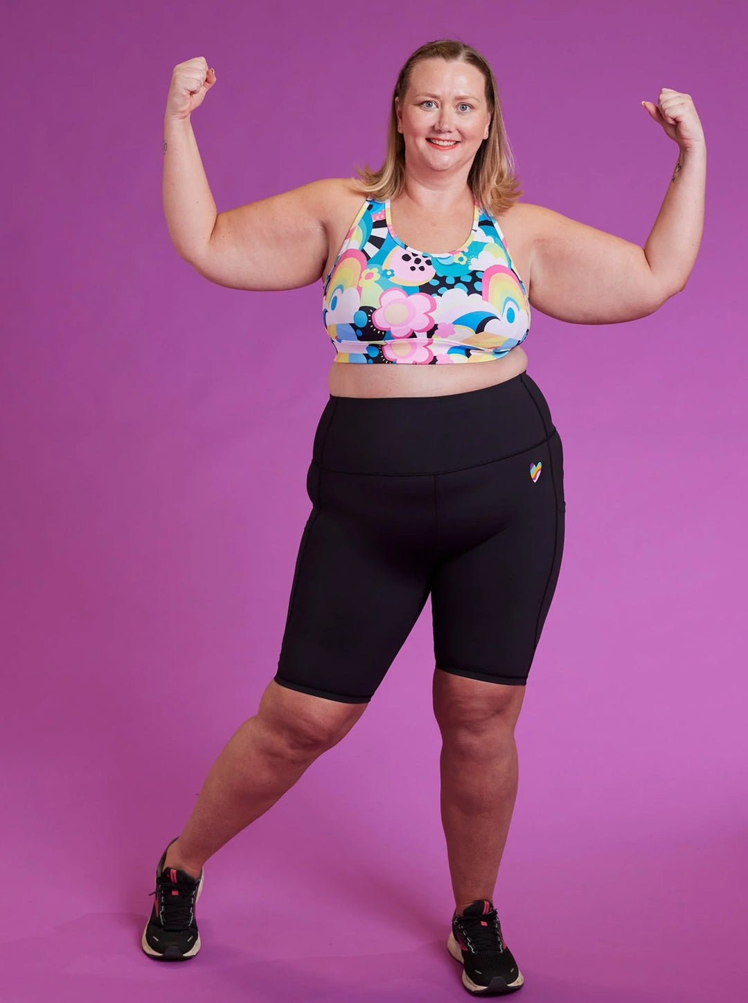 plus size woman wearing colourful active bra and black cycling shorts